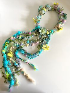 a bunch of beads and flowers on a white surface with one bead in the middle