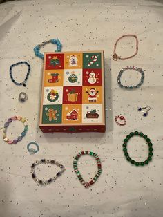 an assortment of beaded bracelets and necklaces laid out on a white sheet