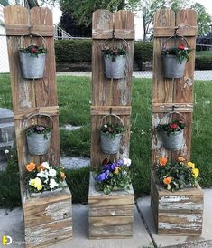 four wooden planters with buckets and flowers on them