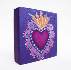 a purple box with a decorative heart painted on it's front and bottom side