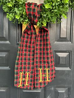 a christmas wreath with the letter h on it hanging from a front door hanger