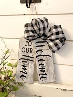 a couple of wooden signs hanging from the side of a building with a bow on it