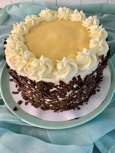 a cake with white frosting and chocolate sprinkles on a blue plate