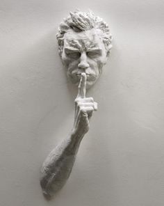 a white statue holding a finger up to its mouth