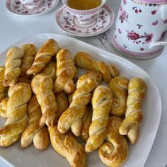 there are many croissants on the plate next to a cup and saucer