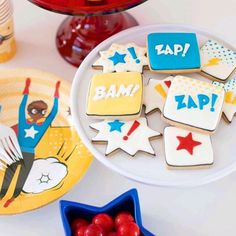 some decorated cookies on a table with plates and cups