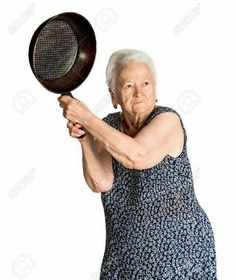 an old woman holding a tennis racquet in her right hand and looking at the camera