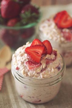 two mason jars filled with oatmeal and strawberries