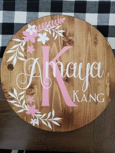 a wooden sign that says anaya kang with flowers and leaves on the front