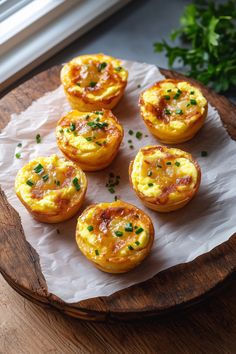 mini quiches with cheese and herbs on a cutting board next to a window,