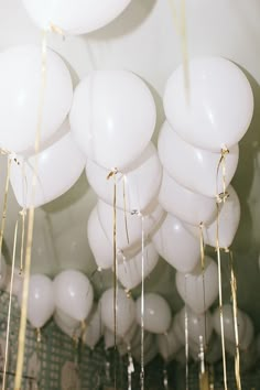 many white balloons are hanging from the ceiling