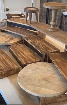 several wooden tables and stools on display in a store or showroom for sale