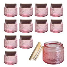 twelve pink glass jars with lids and spoons next to each other on a white background