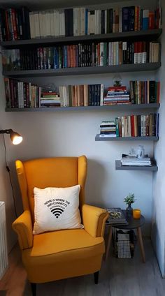 a yellow chair sitting in front of a book shelf filled with books