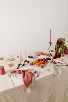 a white table topped with plates and candles