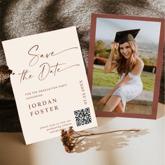 a graduation card with a photo on it next to a flower and a brown hat