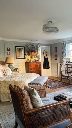 a bed room with a neatly made bed and two chairs