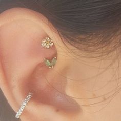 a woman's ear with three small flowers attached to the back of her ear