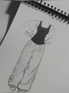 a drawing of a woman's top and pants on a piece of paper next to a pen