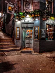 an old building with stairs leading up to the front door and entrance at night time