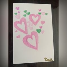 a piece of paper that has hearts drawn on it with pink and green crayons