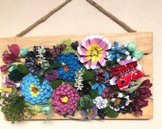 a wooden sign with flowers hanging from it