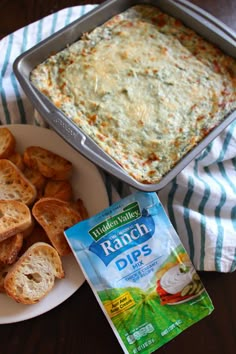 a plate with bread and dip next to a bag of crackers on a table