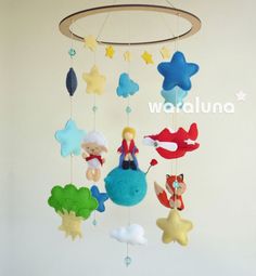 a mobile made to look like the little mermaid with stars and clouds hanging from it