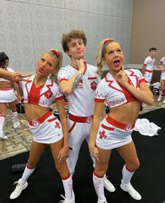 three girls in red and white cheerleader outfits posing for the camera with their hands on their hips