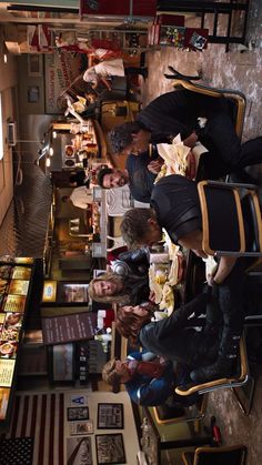 a group of people sitting at a table in a room with pictures on the wall