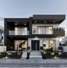 a large modern house with black and white exterior, lights on the balconies