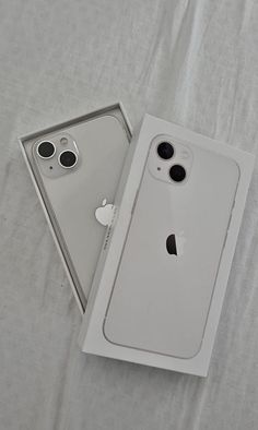 an apple iphone 11 in its box on a white sheeted surface with the cover open