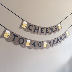 cheers to 40 years banner with beer mugs hanging from the string on the wall