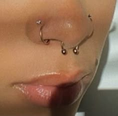 a woman's nose has three piercings on it