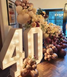 the number 40 is surrounded by balloons and flowers