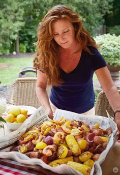 a woman standing over a table filled with food