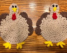 two crocheted turkeys sitting on top of a wooden table