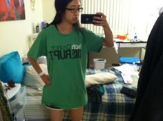 a woman taking a selfie in front of her mirror while wearing shorts and a t - shirt