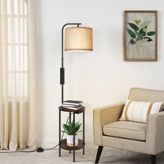 a living room with a chair, table and lamp next to a painting on the wall