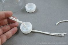 a hand holding a string with two white buttons attached to the end of each button