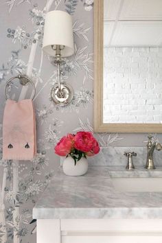 a white sink sitting under a bathroom mirror next to a wall mounted faucet