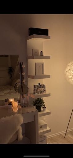 a room with a desk, mirror and lamp in it that is lit by candles