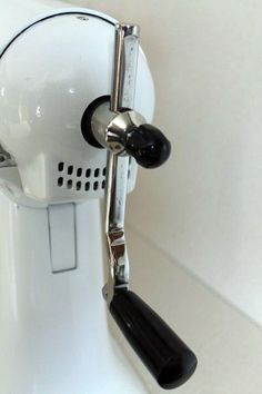 a close up of a coffee maker on a white surface