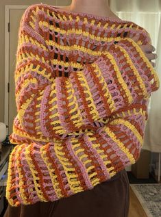 a woman wearing a multicolored crocheted shawl