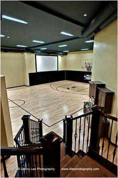 an indoor basketball court with stairs leading up to it