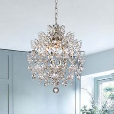 a crystal chandelier hanging from the ceiling in a living room with blue walls