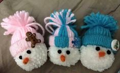 three knitted snowmen wearing hats and scarves on top of a bed next to each other