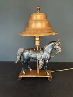 a lamp with a horse figurine sitting on it's base next to a light