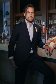 The groom standing at the bar in The Westin Houston Memorial City wearing a blue suit from b.Kreps&Co. Groom And Groomsmen Attire, Editorial Shoot, Funky Socks, Groomsmen Attire, Custom Suit, Glamorous Wedding, Grand Staircase, Groom Attire, Wedding Professional