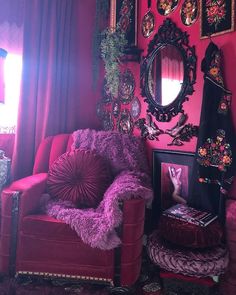 a living room with pink walls and pictures on the wall, including a red chair